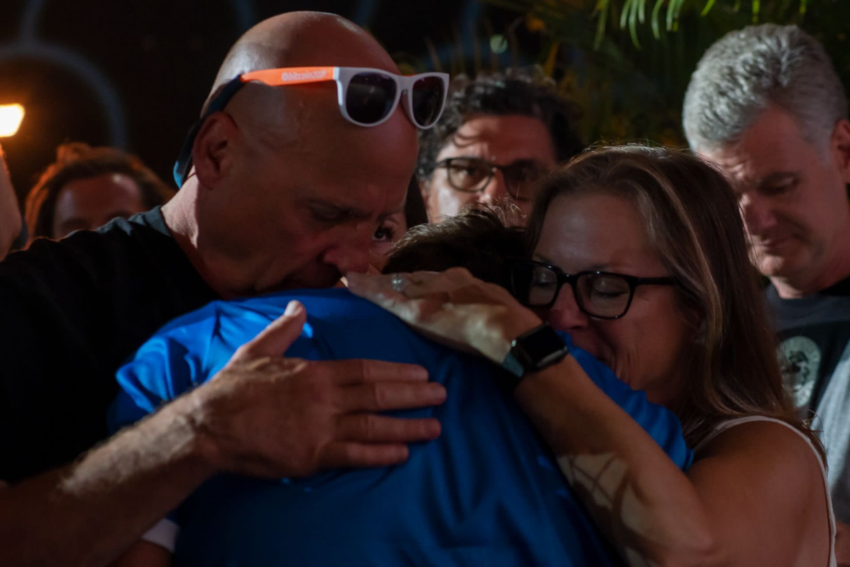 El fundador de la popular aplicación de pagos Strike, Jack Mallers abraza a sus padres tras el anuncio de que El Salvador fue el primero en el mundo en hacer de BTC una moneda nacional.